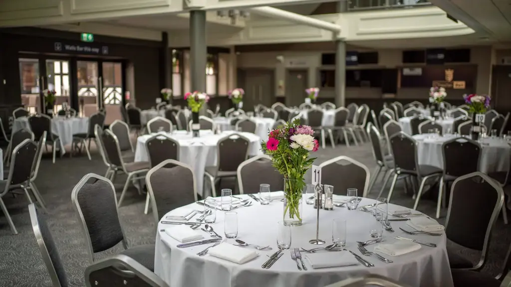 The Long Room laid with round dinner tables, white cloths and flowers