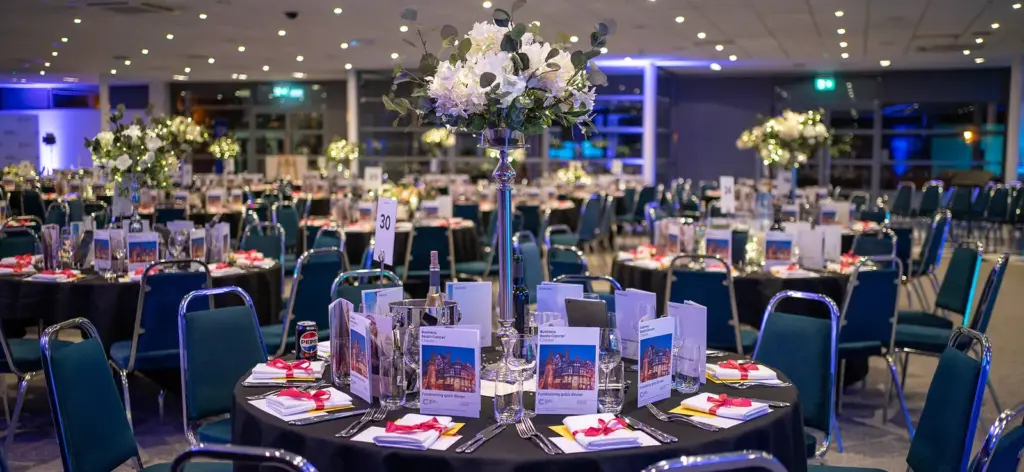 The Pavilion Suite laid for a gala dinner with round tables and tall floral centrepieces