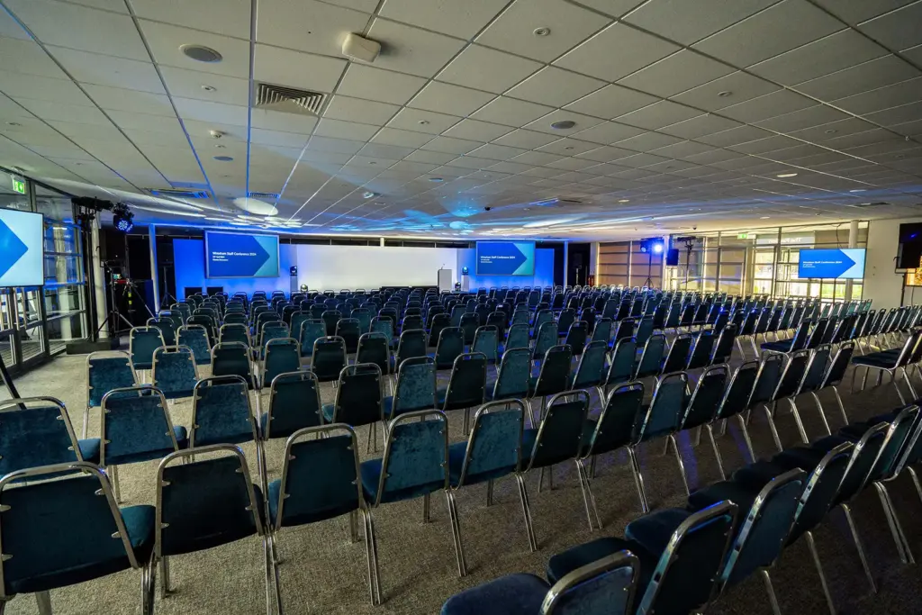 The Pavilion Suite set theatre style with rows of chairs facing a stage, lectern and screens