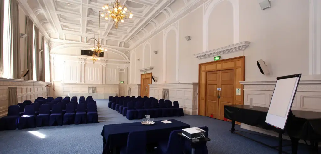 Victoria Hall set theatre style with a top table, flip chart and chandeliers