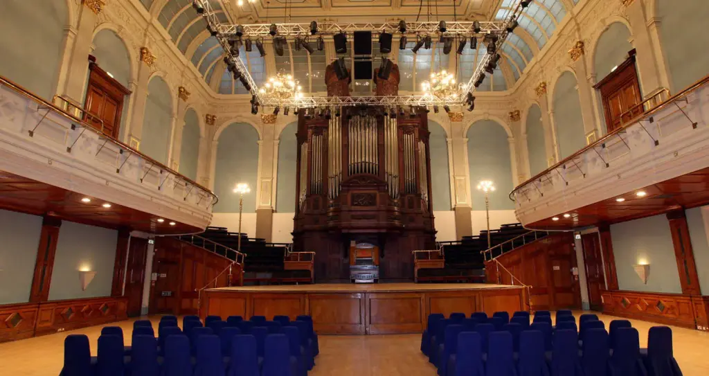 Concert Hall with rows of blue chairs facing the stage, the Father Willis organ and the balcony