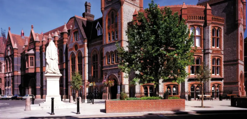 Red brick Victorian Gothic front of Reading Town Hall with the Queen Victoria statue in the square